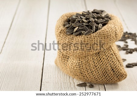 sunflower seeds in bag on wooden background
