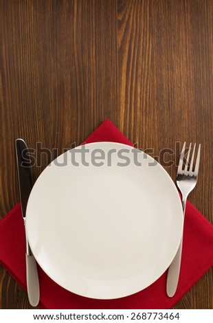 kitchen utensils at cloth napkin on wooden background