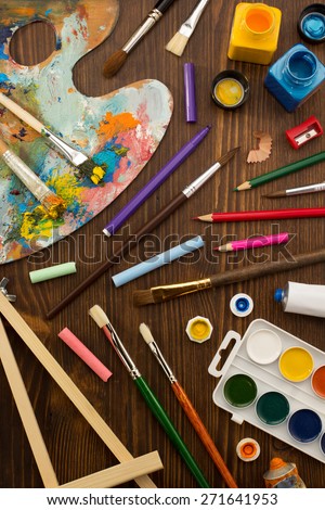 paint supplies and brush on wooden background