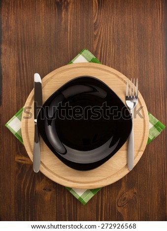 kitchen utensils at cloth napkin on wooden background