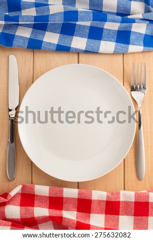 kitchen utensils and cloth napkin on wooden background