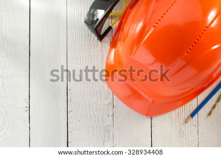 construction helmet and safety glasses on wooden background