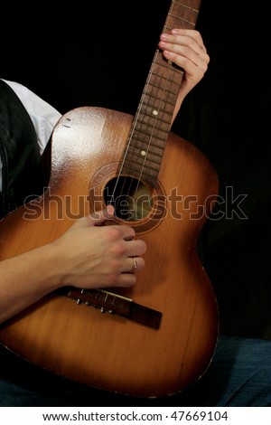 man playing guitar at black background