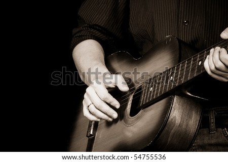 sepia image of man playing guitar
