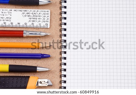 pens, ruler and pencils on pad