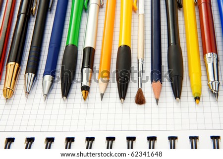 set of pens, pencils on binder pad