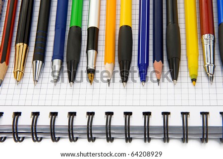 pen and pencils on notebook isolated on white background