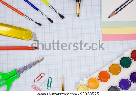 pencils, felt pens, paint brush and scissors on graph grid paper