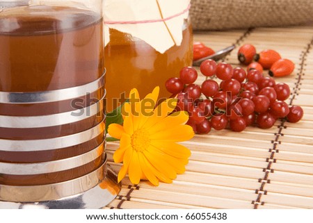 tea with flower, honey, viburnum and sack on wood
