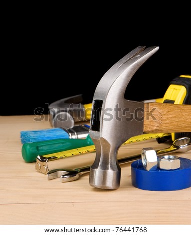 hammer and other construction tools on wooden brick isolated on black