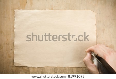 writing hand with pen feather on wood background