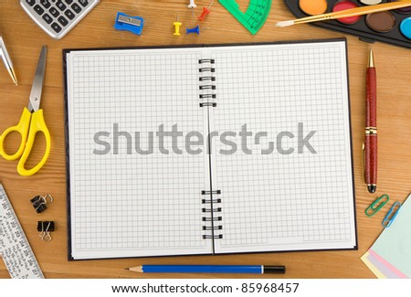 back to school and accessories on checked notebook at wood texture