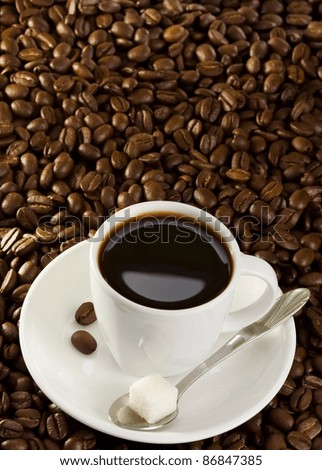 full cup of coffee at roasted beans background