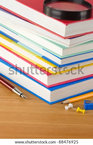 pile of new book and pens on wood background texture