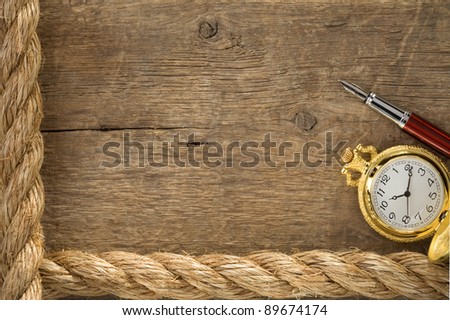 ship ropes and watch with ink pen on old wooden background