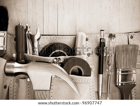 tools in construction belt on wooden background texture