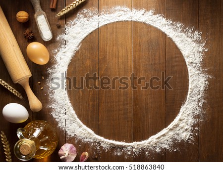 flour powder and  bakery ingredients on wooden background