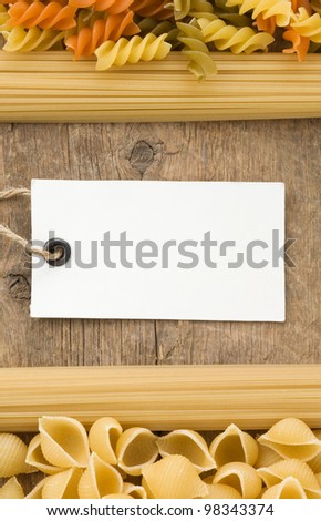 raw pasta and price tag on wood background texture