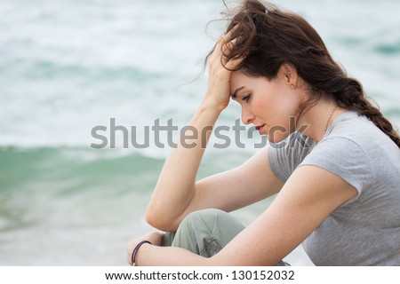 Close-up of a sad and depressed woman deep in thought outdoors.