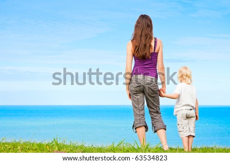 stock photo : A young mother and child holding hands and looking at 