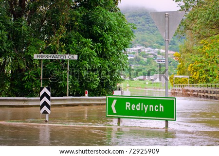 Flooded roundabout, road signs and bridge in Queensland, Australia after heavy rain
