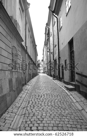 A black and white photo taken down a narrow street