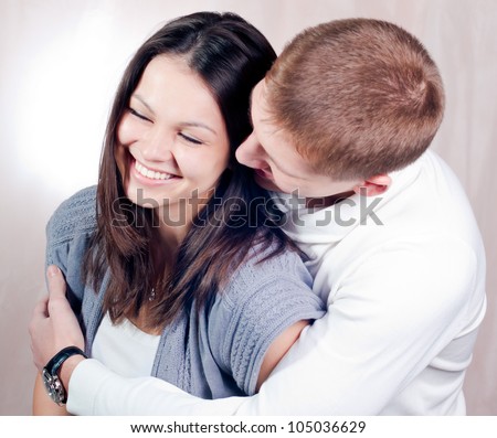Gentle hug: Portrait of a beautiful happy smiling couple handsome young man wearing watches gently hugging pretty woman in fun and love mood