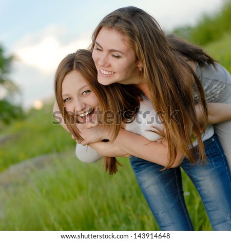 Two Happy Young Women Girl Friends Laughing In Spring Or Summer Outdoors Background