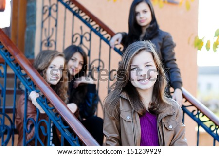 Four happy teen girls friends outdoors smiling and having fun