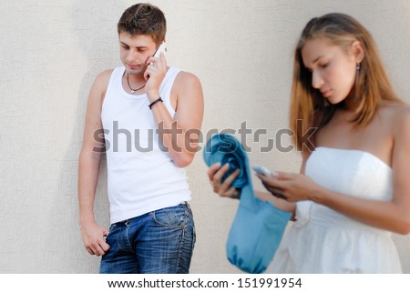 Young man calling to his girlfriend woman female friend and she picks up mobile phone