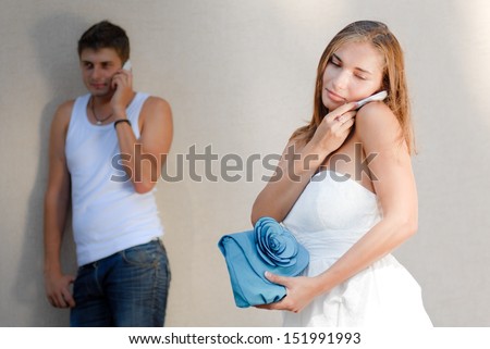 Young man calling to his girlfriend woman female friend and she picks up mobile phone