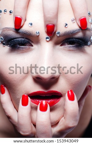 Wild animal or vampire looking woman with bright red lips and manicure