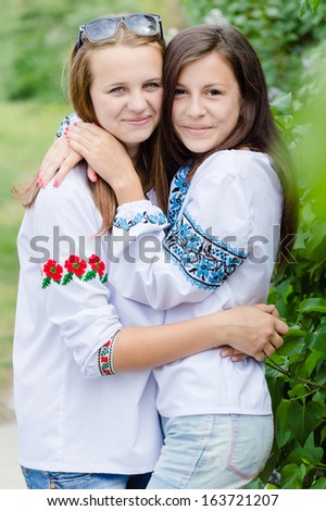 Two Teen Girl Friends happy smiling & looking at camera on spring or summer outdoors background