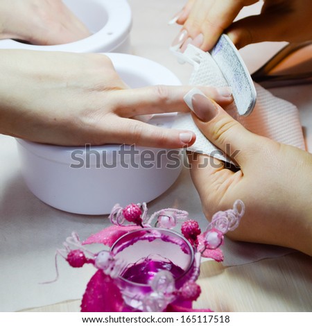 Woman manicure procedure in beautician salon closeup on hands