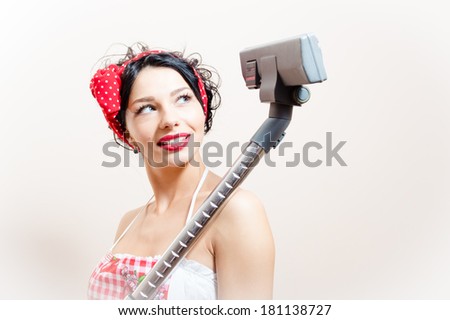 portrait of beautiful funny young woman brunette pinup girl with vacuum cleaner looking up on white background