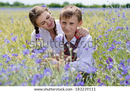 Mother and son hugging on summer outdoors background