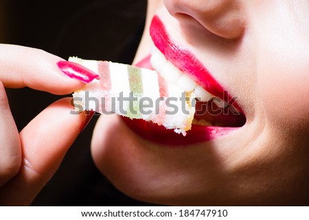Woman with red, seductive lips and nail biting jujube, candy, closeup
