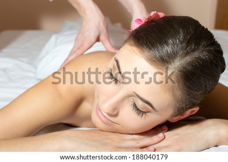 closeup on tired pretty woman lying on a table and taking beauty massages procedure