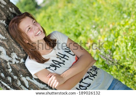 Young pretty woman happy teenage girl laughing joyfully on summer day outdoors in park copy space
