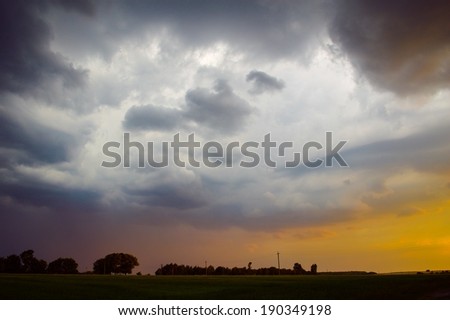 image of dramatic thunder storm clouds at sunset landscape