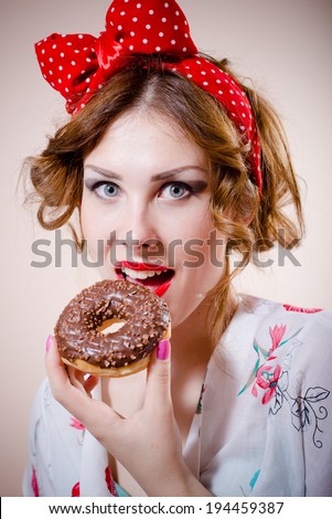 closeup portrait of pinup girl beautiful blond young woman with excellent dental care teeth having fun eating donut happy smiling & looking at camera on white background