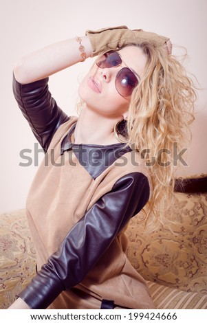 picture of beautiful attractive young woman with collected blond hair in brown dress with leather sleeves and collar having fun posing looking at camera portrait on copy space background
