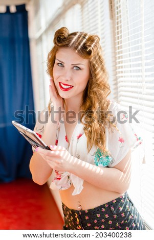 picture of enjoying reading news on tablet pc computer pinup sexy pretty girl having fun happy smile looking at camera at home on sun lighting window blinds copy space background portrait