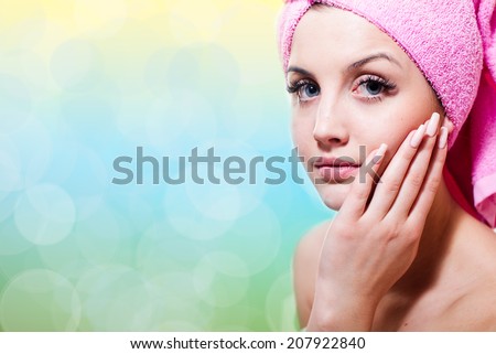 spa time: blue eyes sexy woman in towel touching her face silk skin & looking at camera on light copy space background, closeup portrait