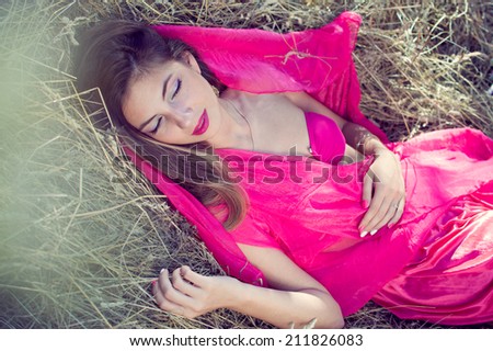 sleeping beauty: elegant young pretty lady having fun relaxing sleeping outdoors on green grass copy space background