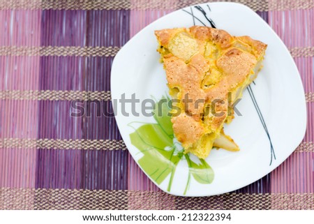 Piece of tasty biscuit apple pie on square plate and purple bamboo napkin