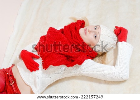 Beautiful happy smiling blond & blue eyes young woman wearing red knitted gloves and shawl looking at camera