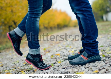 Teenage couple feet closeup in black leather shoes when reaching for kiss