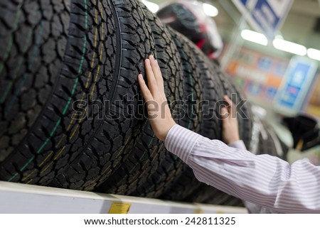 hands of man or woman touching & choosing for buying a tire in a supermarket mall