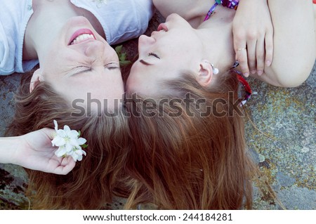 closeup portrait of lying head to head happy girl friends relaxing happy smiling